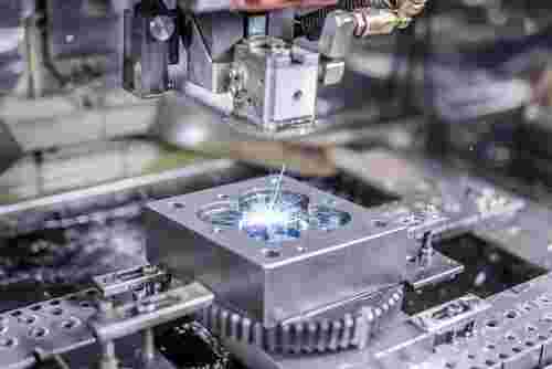 Draht-EDM in moderner Werkstatt; Funken am Werkstück, präzise Konturen, Stahl, Edelstahl, Titan