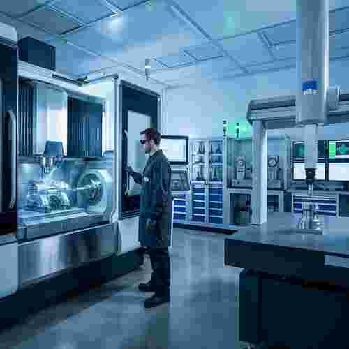 CNC-Fräsmaschine mit Werkstück, Techniker beobachtet; CMM misst.