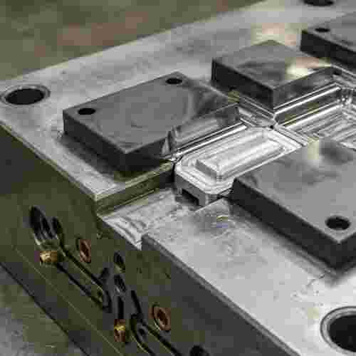 Querschnitt einer Spritzgießform: Stahlbasis mit Karbid-Einsätzen, Kühlkanäle, Aluminiumprototyp