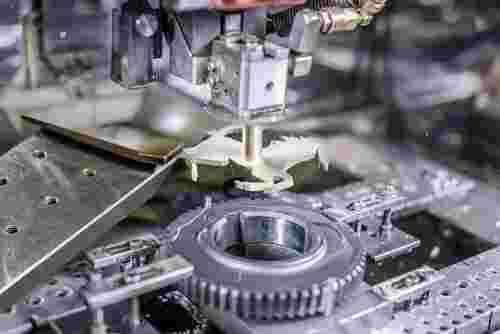 Nahaufnahme einer modernen Drahterodiermaschine in einer sauberen Werkstatt, präzise Bearbeitung.