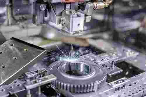 Nahaufnahme eines Draht-EDM-Prozesses: Draht erodiert Metallwerkstück, Funken, moderne Industrie.