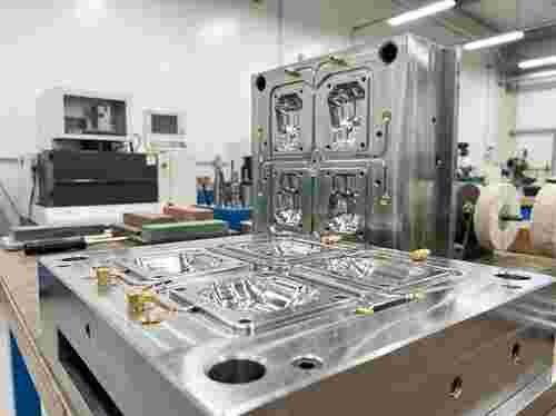 Nahaufnahme eines hochpräzisen Spritzgießwerkzeugs mit Kavitäten, Kühlkanälen und polierten Oberflächen