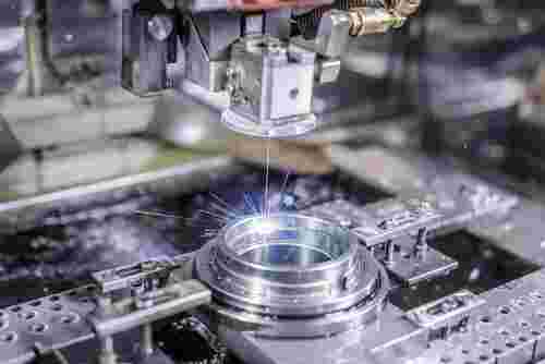 nahaufnahme einer draht-edm-maschine bei der bearbeitung eines metallwerkstücks mit funken