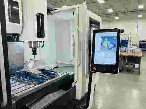 3-Achs-Fräsmaschine in moderner Fertigung, Prismenteil-Fräsen, CAM/CNC-Schnittstelle sichtbar