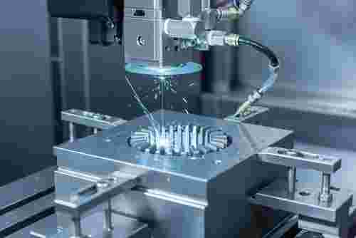 Draht-EDM-Bearbeitung eines harten Metallbauteils mit Funken, präzise Konturen.