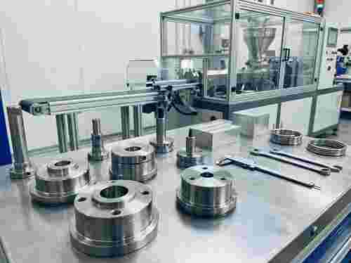 Nahaufnahme von Extrusionswerkzeugen; Edelstahl- und Aluminiumoberflächen, Kunststoffproduktion.