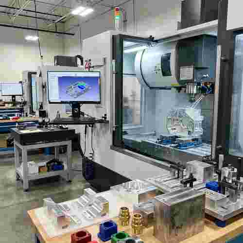 Moderne Werkstatt mit 3- und 5-Achs-CNC-Fräsen bearbeitet Aluminiumteile, Späne, CAM/CAD-Monitor
