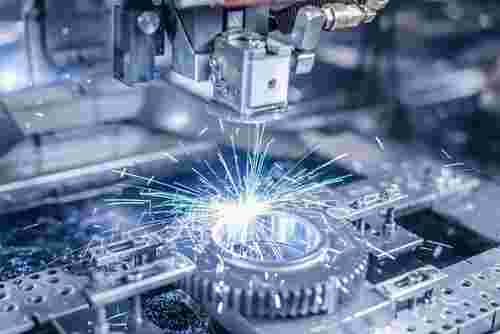 Draht-EDM-Bearbeitung: feine Mikromerkmale am Werkstück, Funken, blaues Licht, Präzision