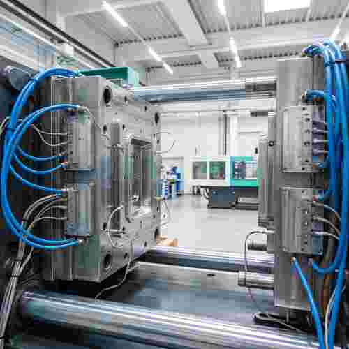 Spritzgießwerkzeug in sauberer Fabrik mit Kühlkanälen, temperaturgesteuerten Formplatten und Sensoren.