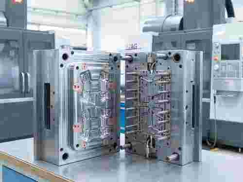 Nahaufnahme eines offenen Spritzgießwerkzeugs mit Kavität, Ejektorseite und Kühlkanälen aus Stahl